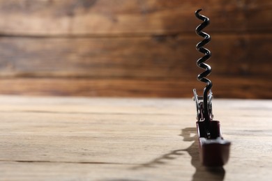 One corkscrew (sommelier knife) on wooden table, closeup. Space for text