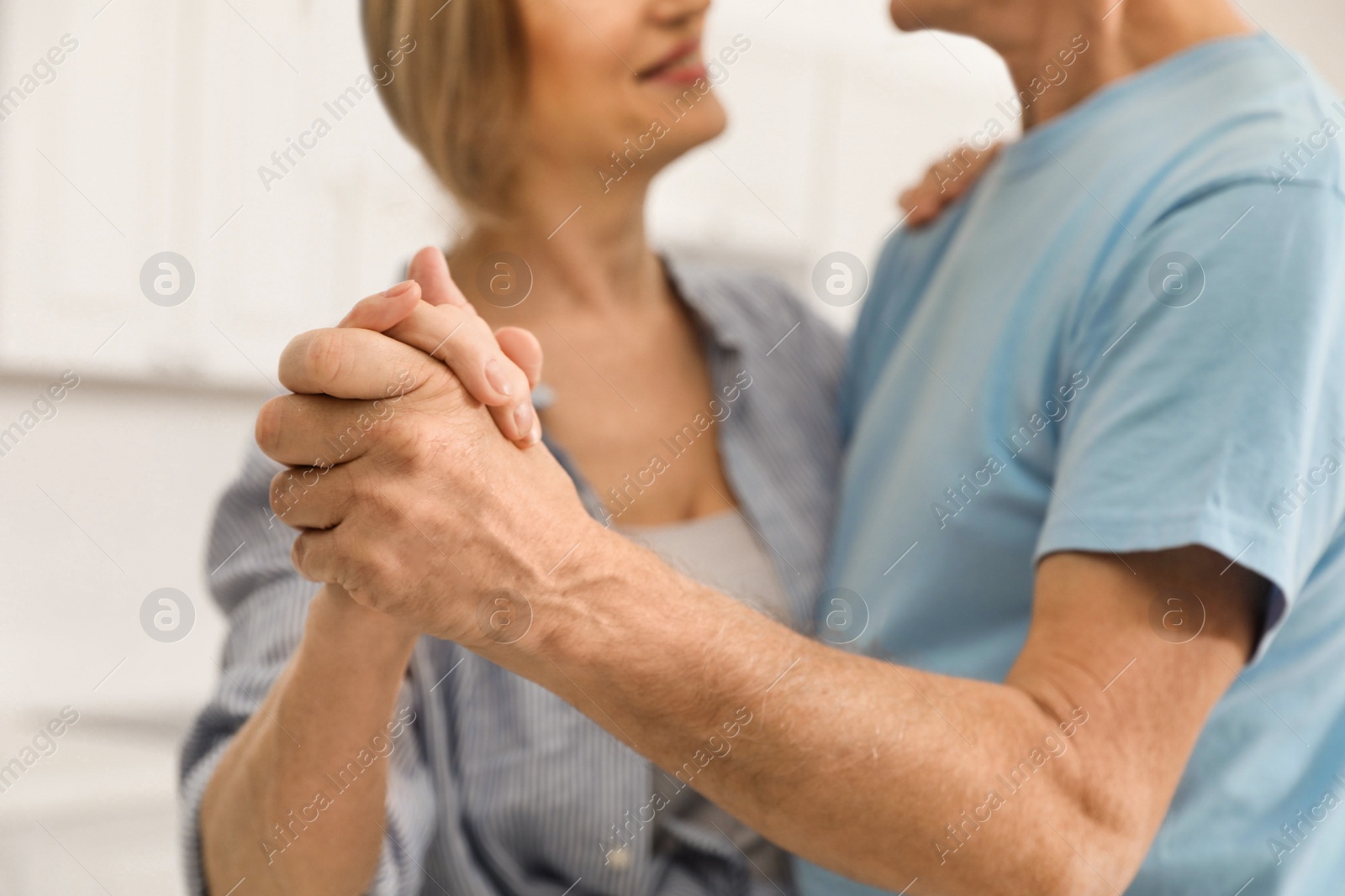 Photo of Happy senior couple dancing together at home, closeup