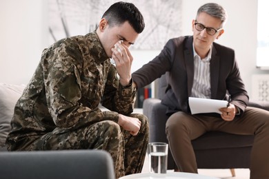 Photo of Professional psychotherapist working with military man in office