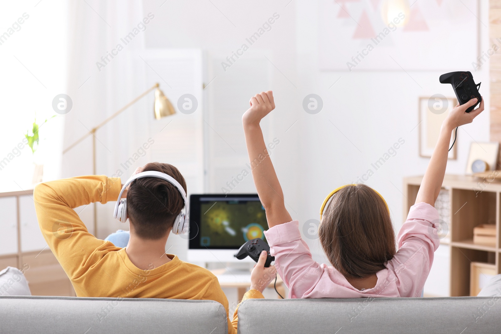 Photo of Emotional young couple playing video games at home