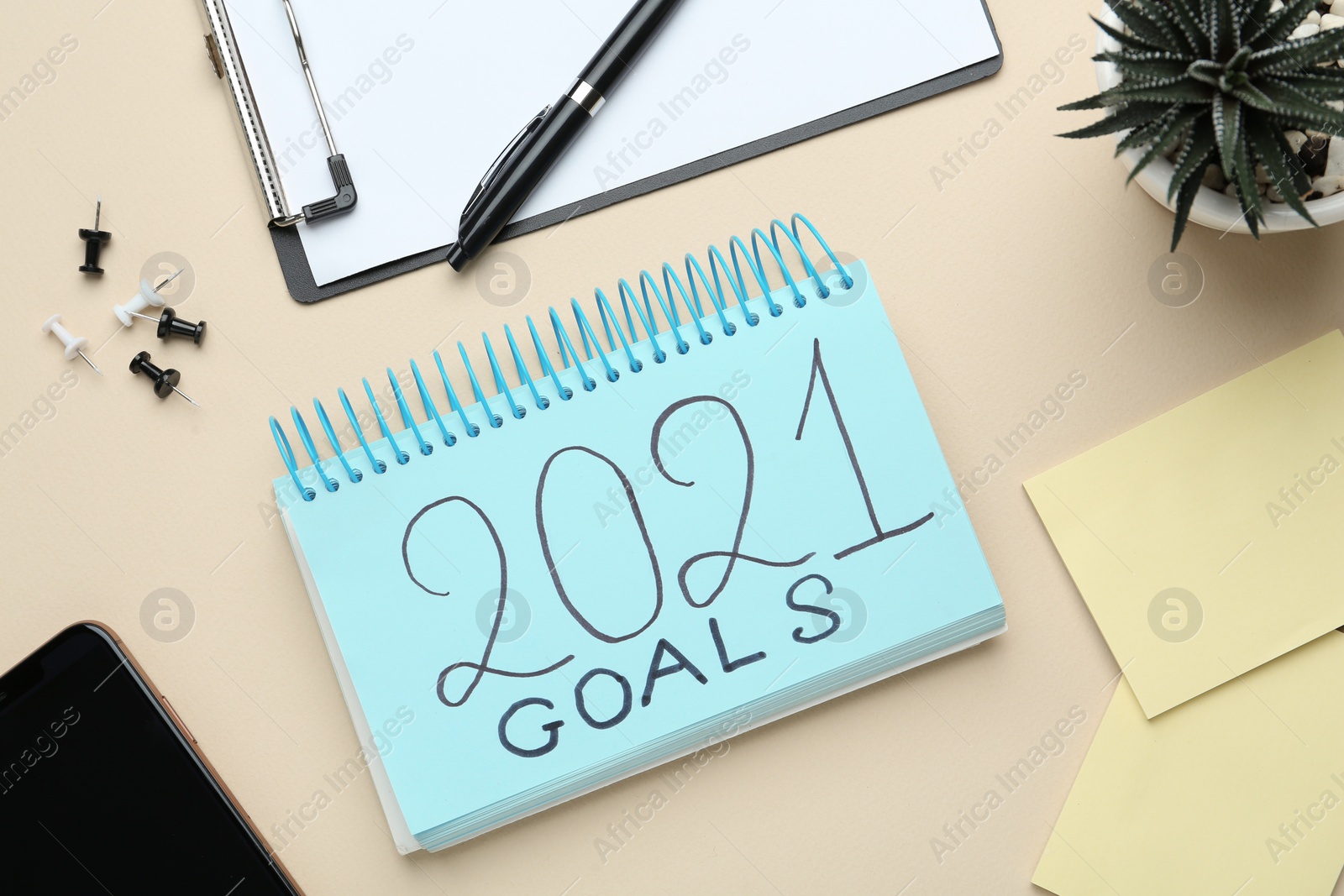 Photo of Flat lay composition with notebook on beige background. Goals for New Year 2021