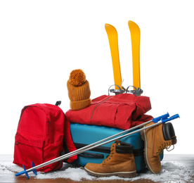 Photo of Suitcase with warm clothes and skis isolated on white. Winter vacation