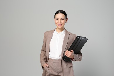 Photo of Beautiful real estate agent with documents on grey background