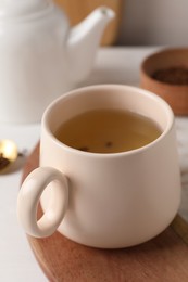 Photo of Cup of aromatic buckwheat tea on table, closeup