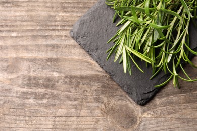 Fresh green rosemary on wooden table, top view. Space for text