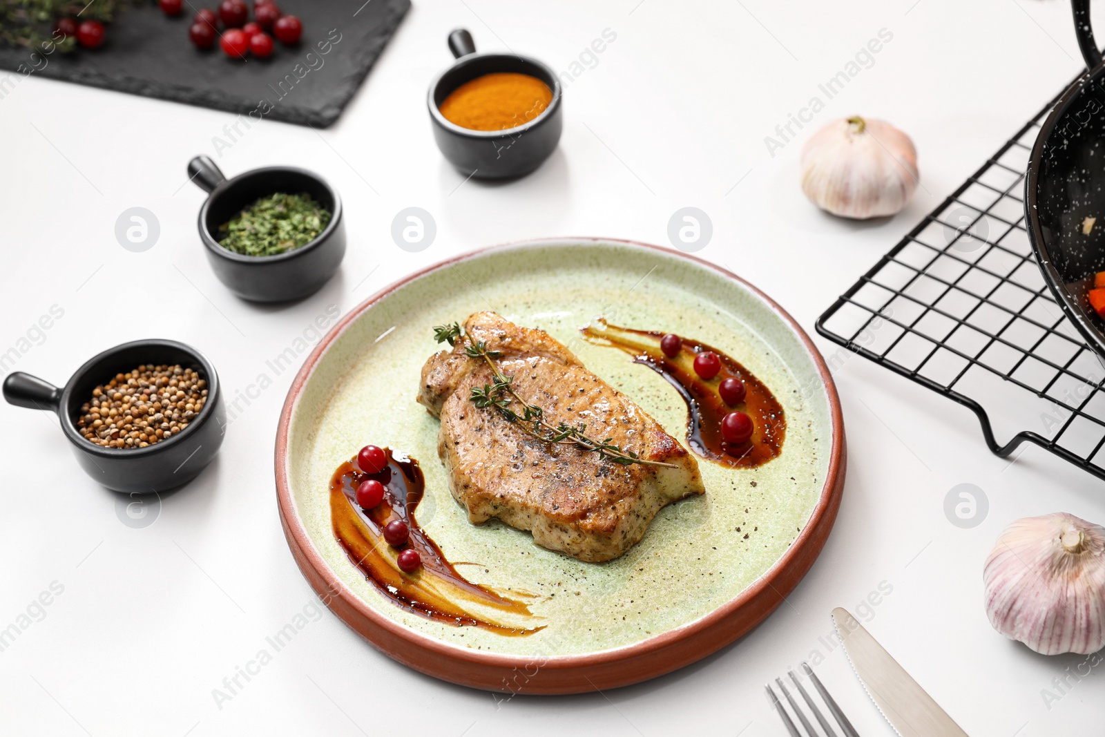 Photo of Beautiful composition with plate of delicious meat on white table in studio. Food stylist