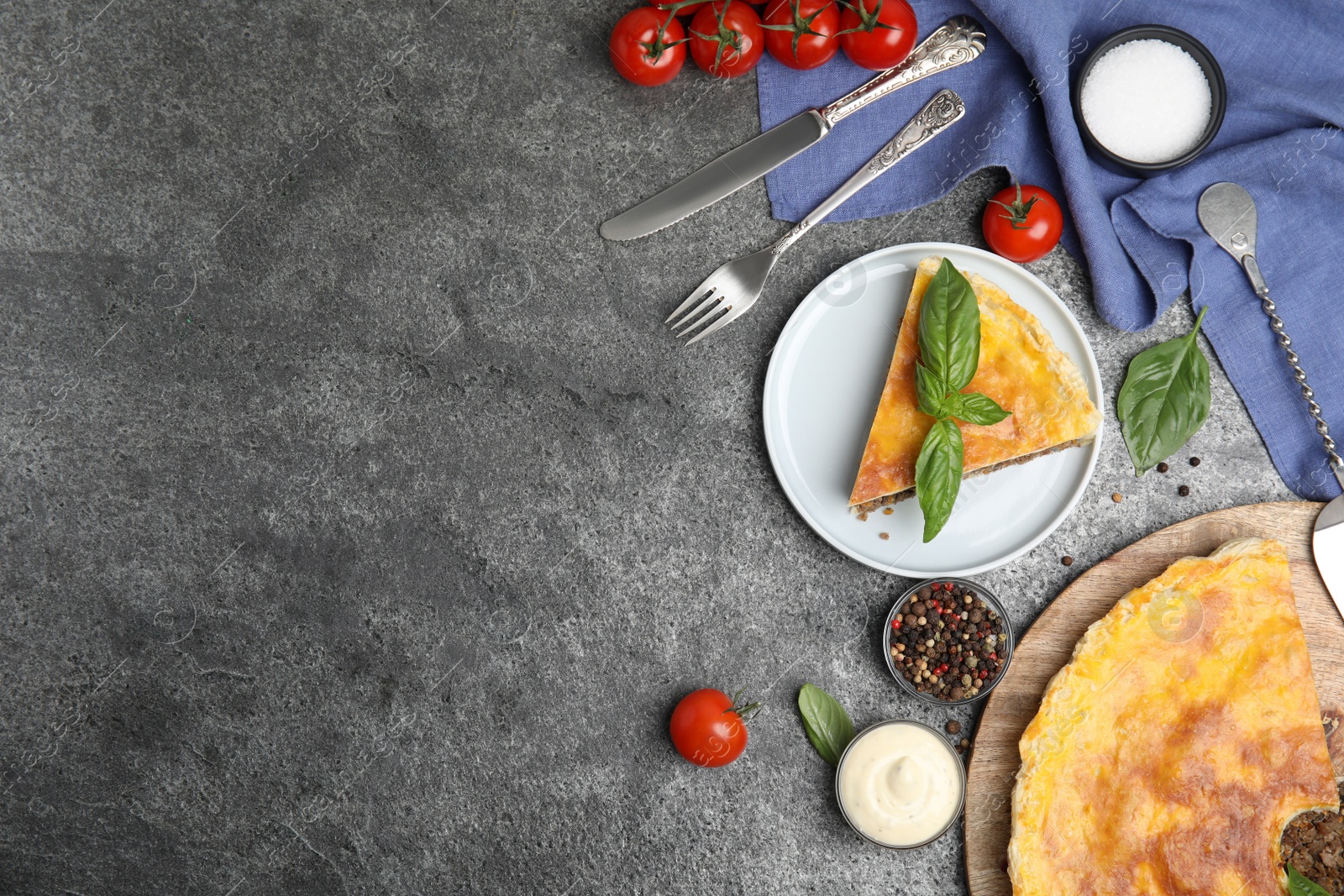 Photo of Delicious pie with minced meat served on grey table, flat lay. Space for text