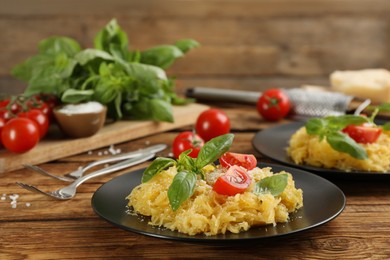 Photo of Tasty spaghetti squash with tomatoes and basil served on wooden table