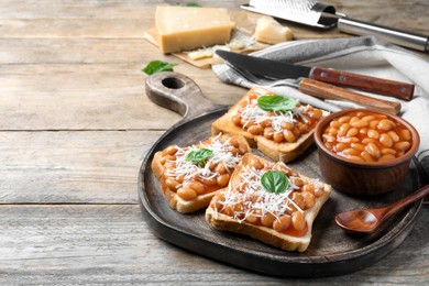 Photo of Toasts with delicious canned beans on wooden table, space for text