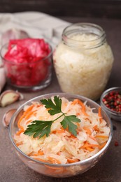 Photo of Delicious sauerkraut prepared according to different recipes on brown table, closeup view