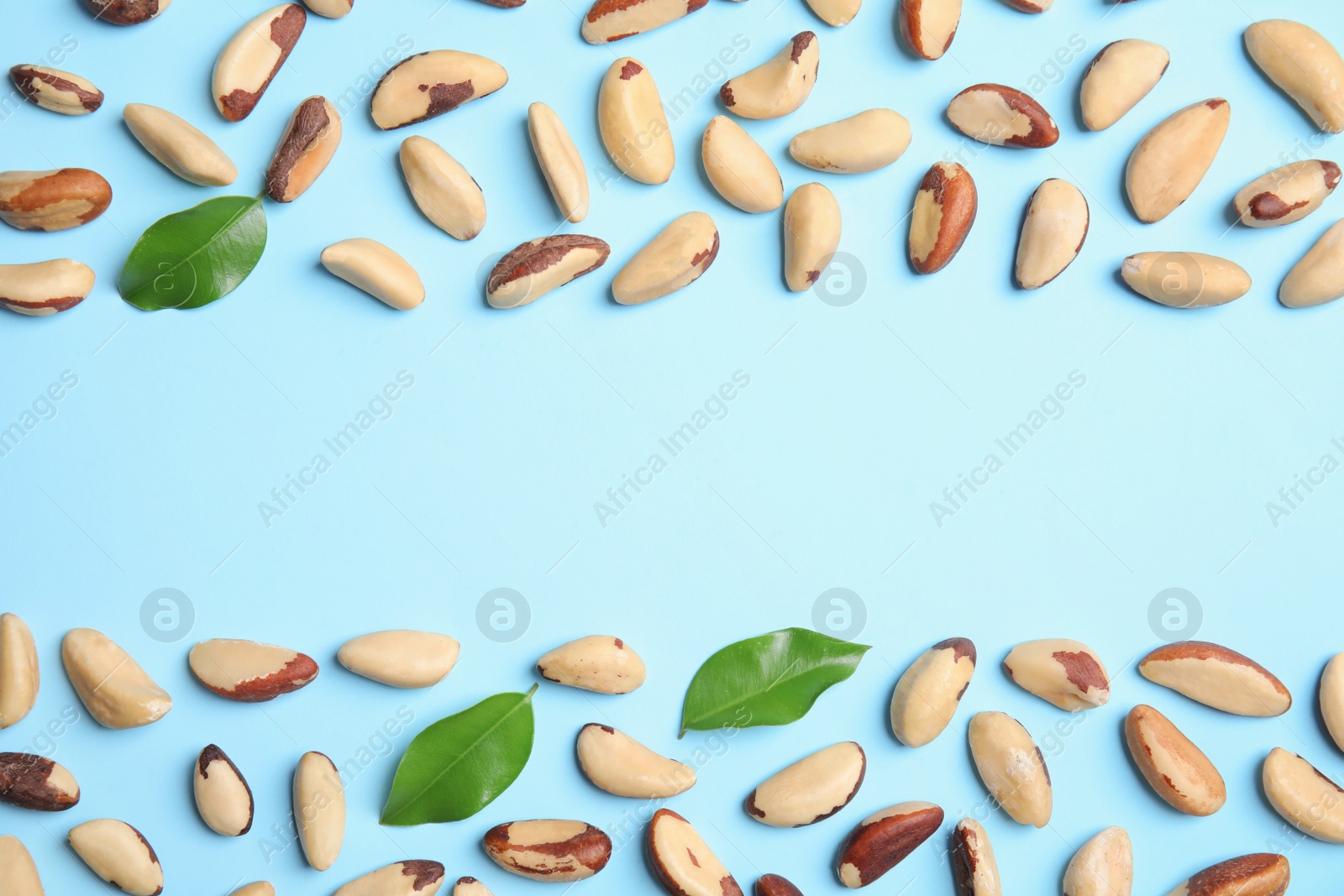 Photo of Flat lay composition with Brazil nuts, leaves and space for text on color background