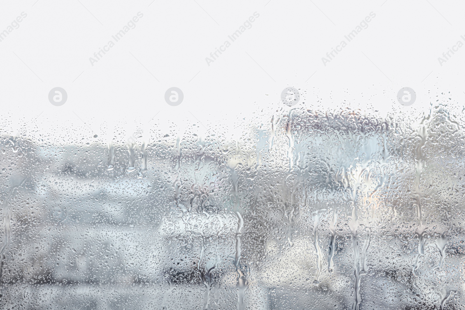 Photo of Blurred view of city from window on rainy day