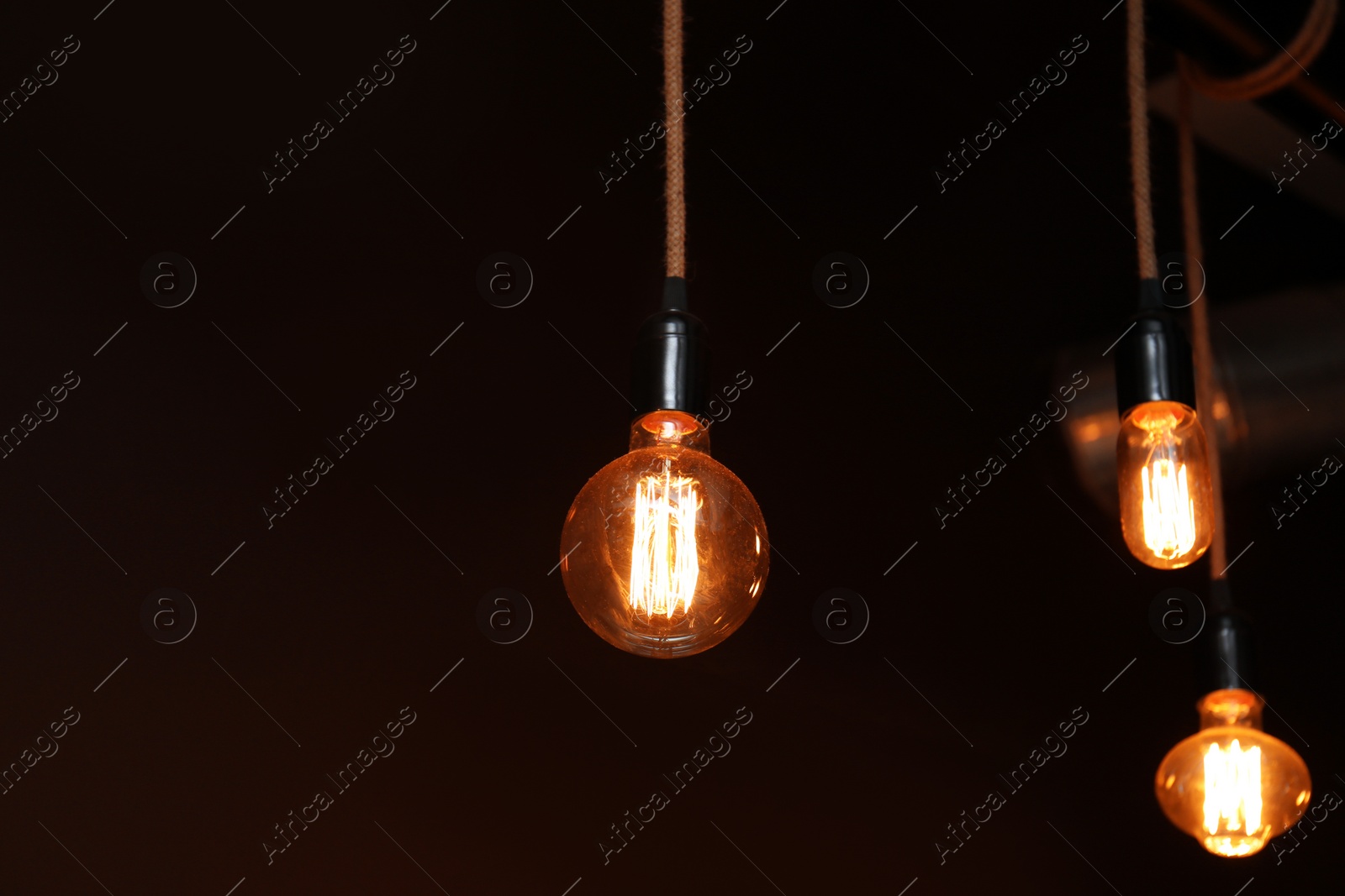 Photo of Lamp bulbs in darkness. Space for text