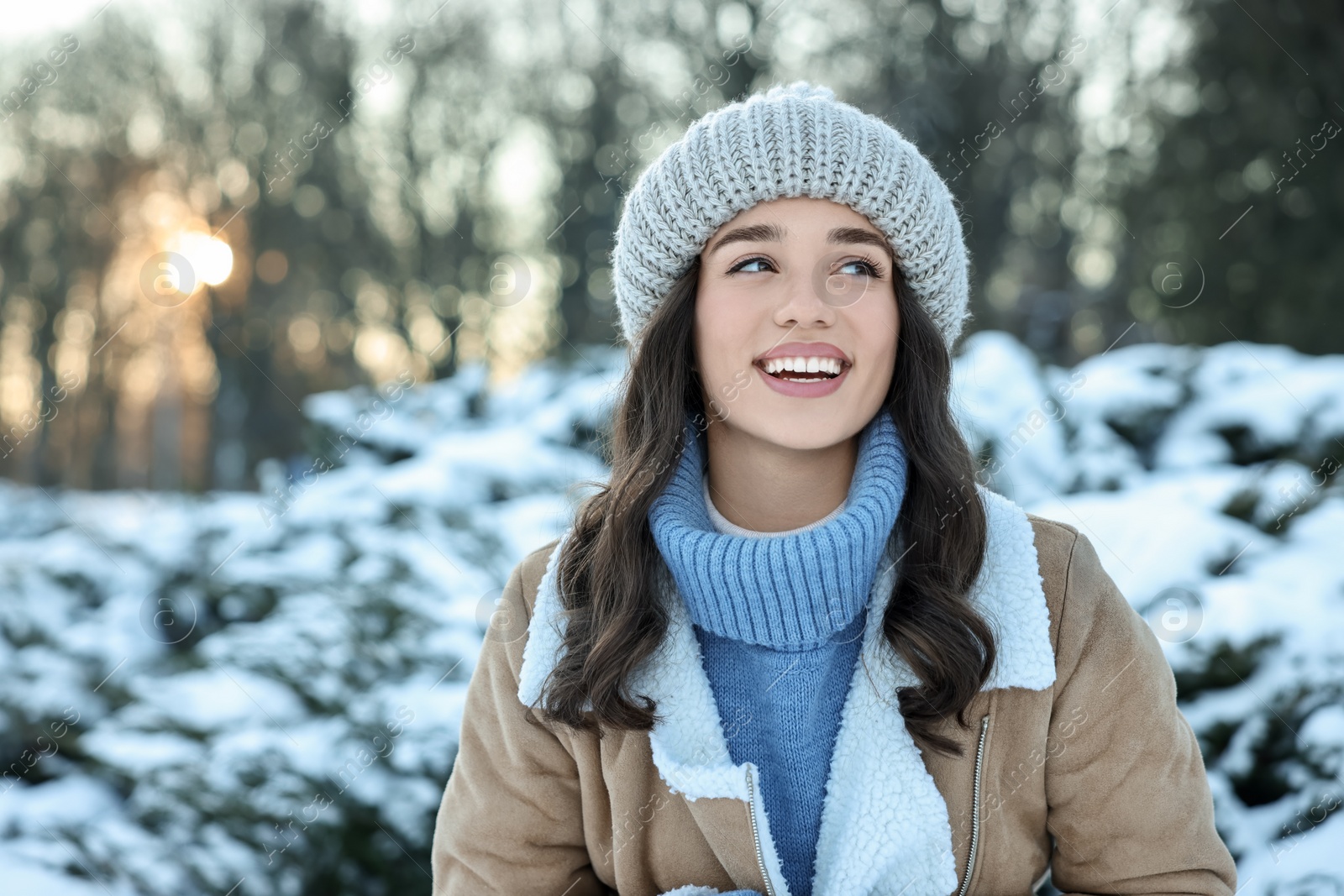 Photo of Portrait of happy woman in snowy park. Space for text