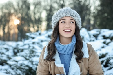 Photo of Portrait of happy woman in snowy park. Space for text