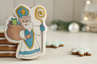 Photo of Delicious gingerbread cookies on white wooden table, closeup with space for text. St. Nicholas Day celebration