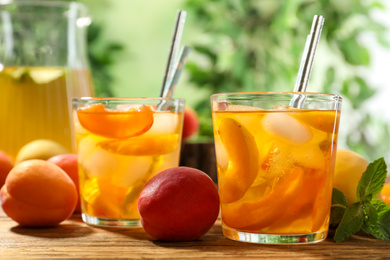 Photo of Delicious refreshing drink with apricot on wooden table, closeup
