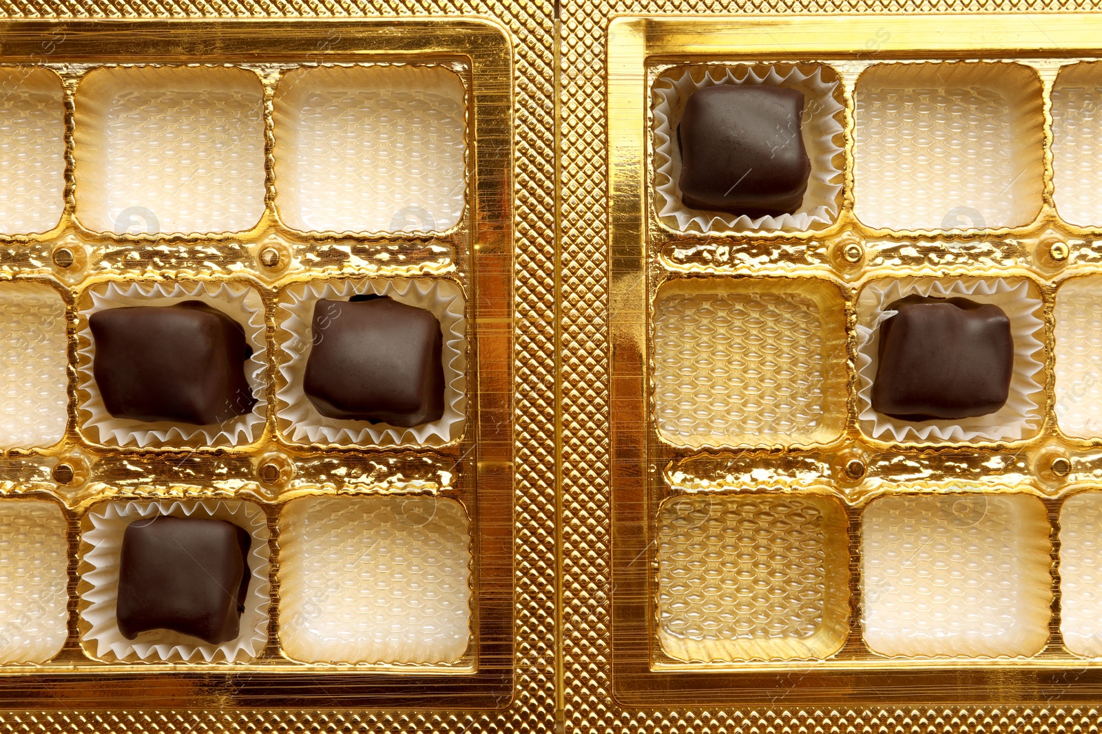 Photo of Partially empty box of chocolate candies as background, top view