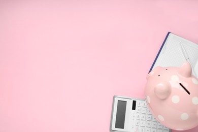 Calculator, piggy bank, notebook and pen on pink background, flat lay. Space for text