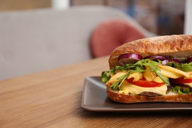 Photo of Plate with yummy sandwich on table in cafe. Space for text