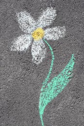 Photo of Flower drawn with colorful chalks on asphalt outdoors, top view