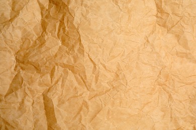 Photo of Texture of crumpled brown baking paper as background, closeup