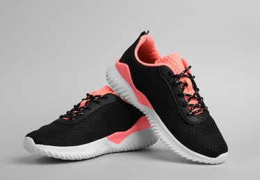 Pair of comfortable sports shoes on grey background