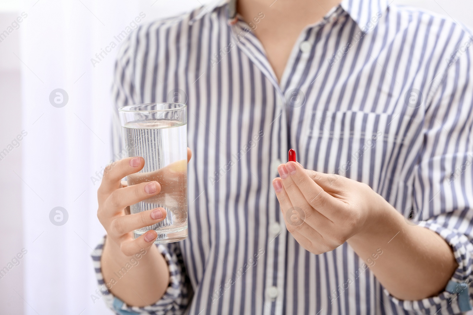 Photo of Young woman with pill and glass of water, closeup