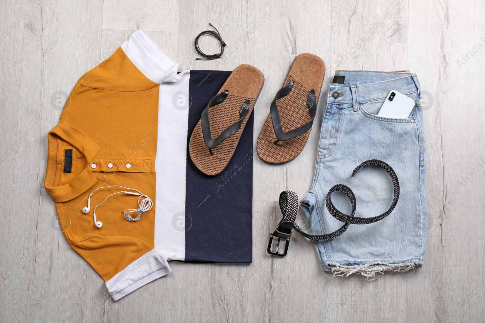 Photo of Set of stylish clothes and accessories on wooden floor, flat lay