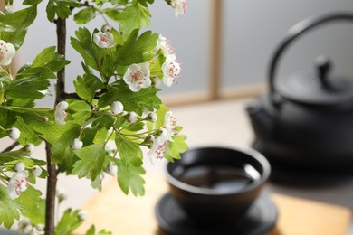 Photo of Stylish ikebana as house decor. Beautiful fresh branch with flowers on blurred background, closeup and space for text