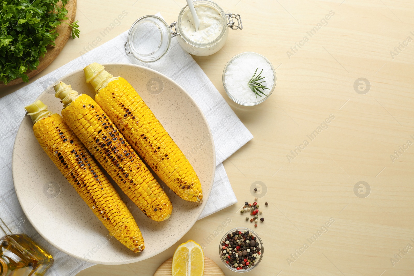 Photo of Flat lay composition with tasty grilled corn on wooden table. Space for text