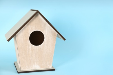 Photo of Beautiful bird house on light blue background, space for text