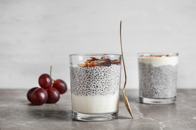 Tasty chia seed pudding with granola and spoon on table