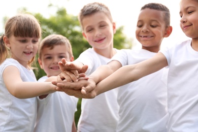 Group of kids joining hands in park. Volunteer project