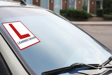 Modern car with L-plate sign on window, closeup