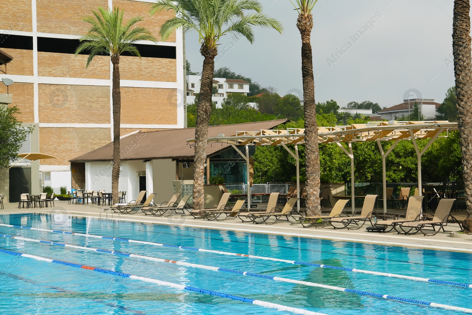 Photo of Swimming pool and sunbeds at luxury resort