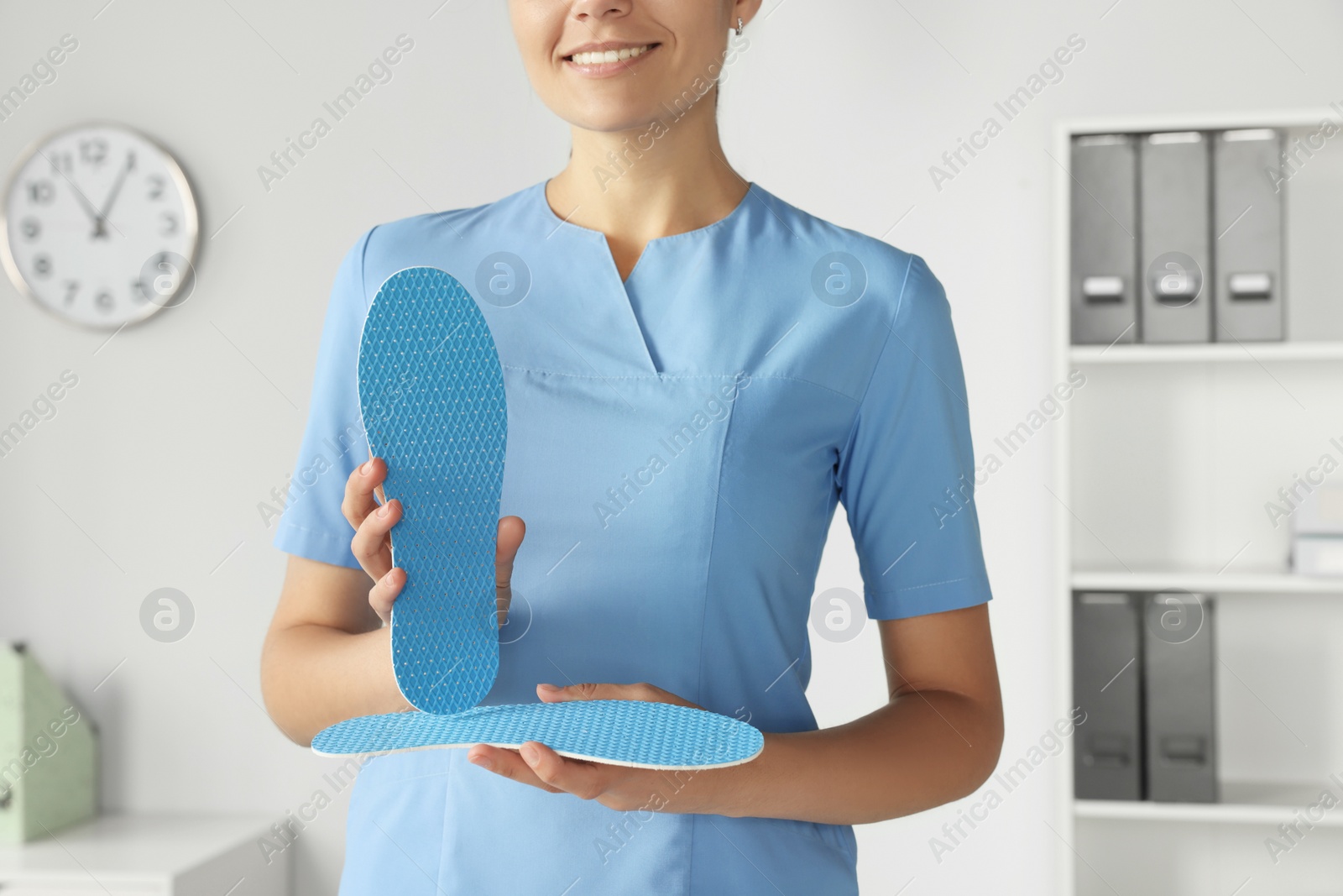 Photo of Female orthopedist showing insole in hospital, closeup