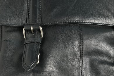 Photo of Black natural leather with buckle as background, closeup view