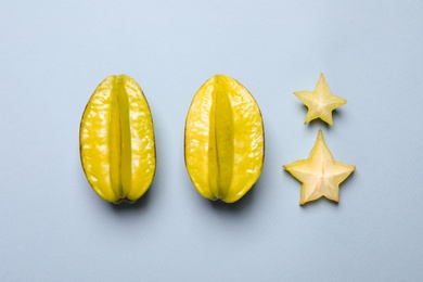 Delicious carambola fruits on light grey background, flat lay