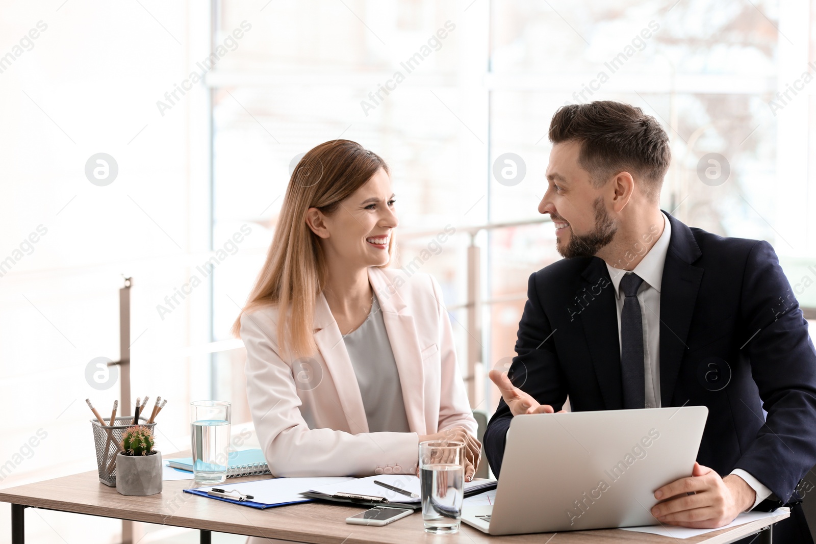 Photo of Young consultant working with client in office