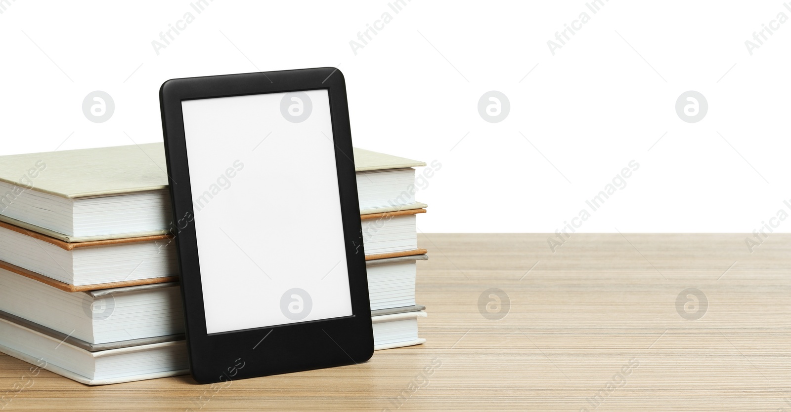 Photo of Stack of hardcover books and modern e-book on wooden table against white background. Space for text