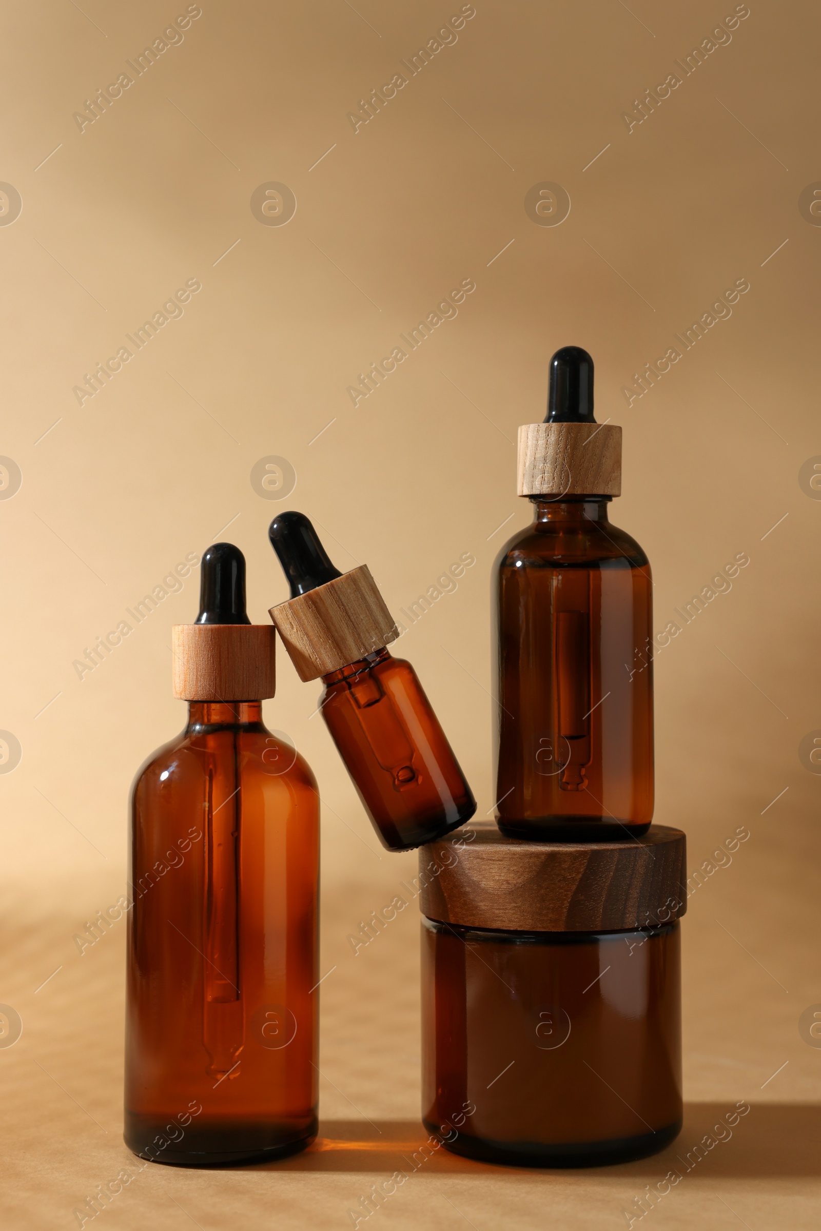 Photo of Set with different luxury cosmetic products on dark beige background