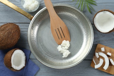Photo of Flat lay composition with frying pan and organic coconut cooking oil on grey wooden table