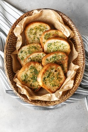 Photo of Slices of toasted bread with garlic and herbs on grey table, top view