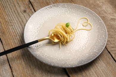 Photo of Heart made with spaghetti and fork on wooden table