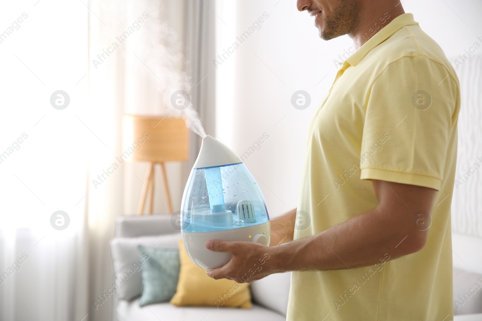 Photo of Man with modern air humidifier at home, closeup