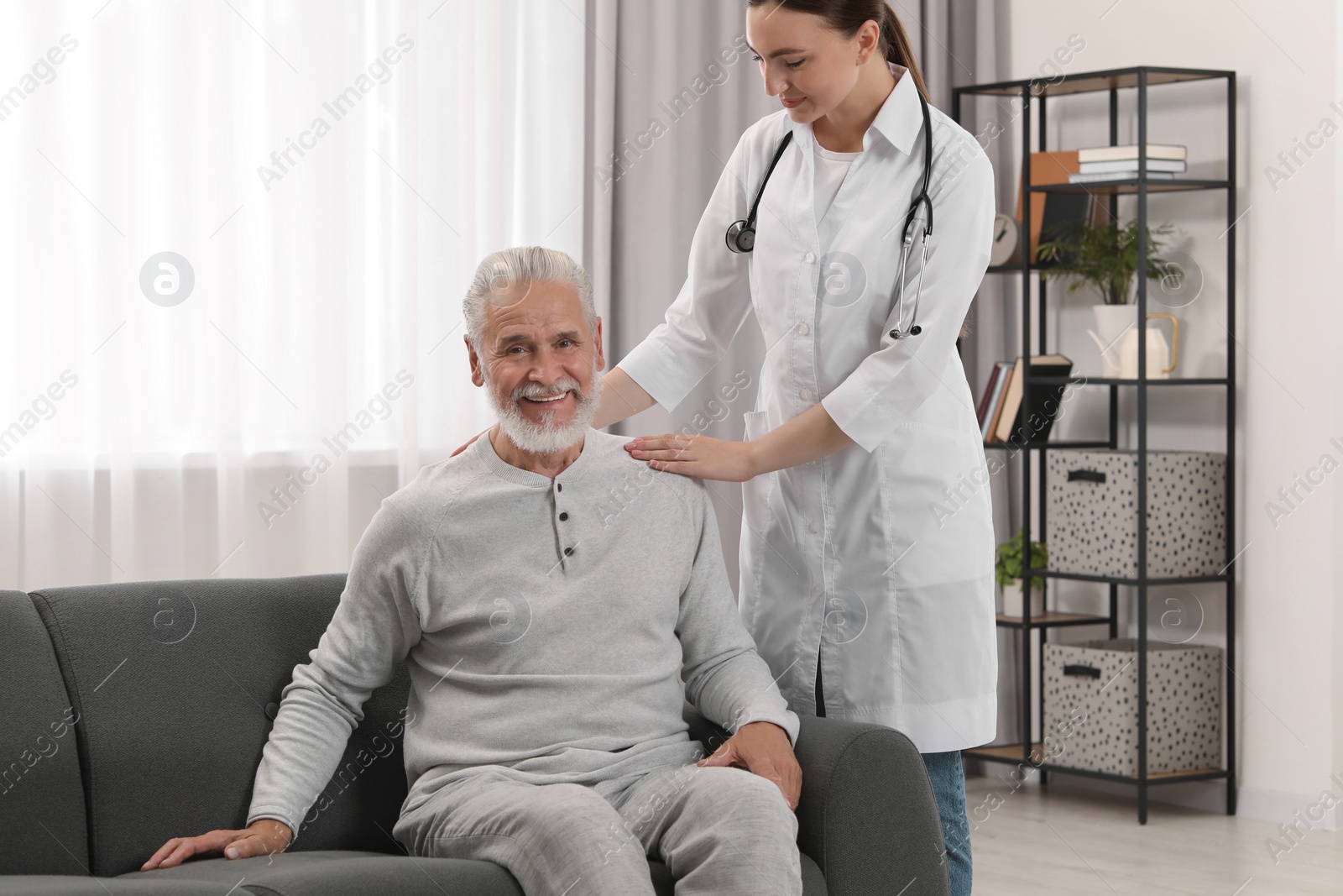 Photo of Young healthcare worker and senior man indoors