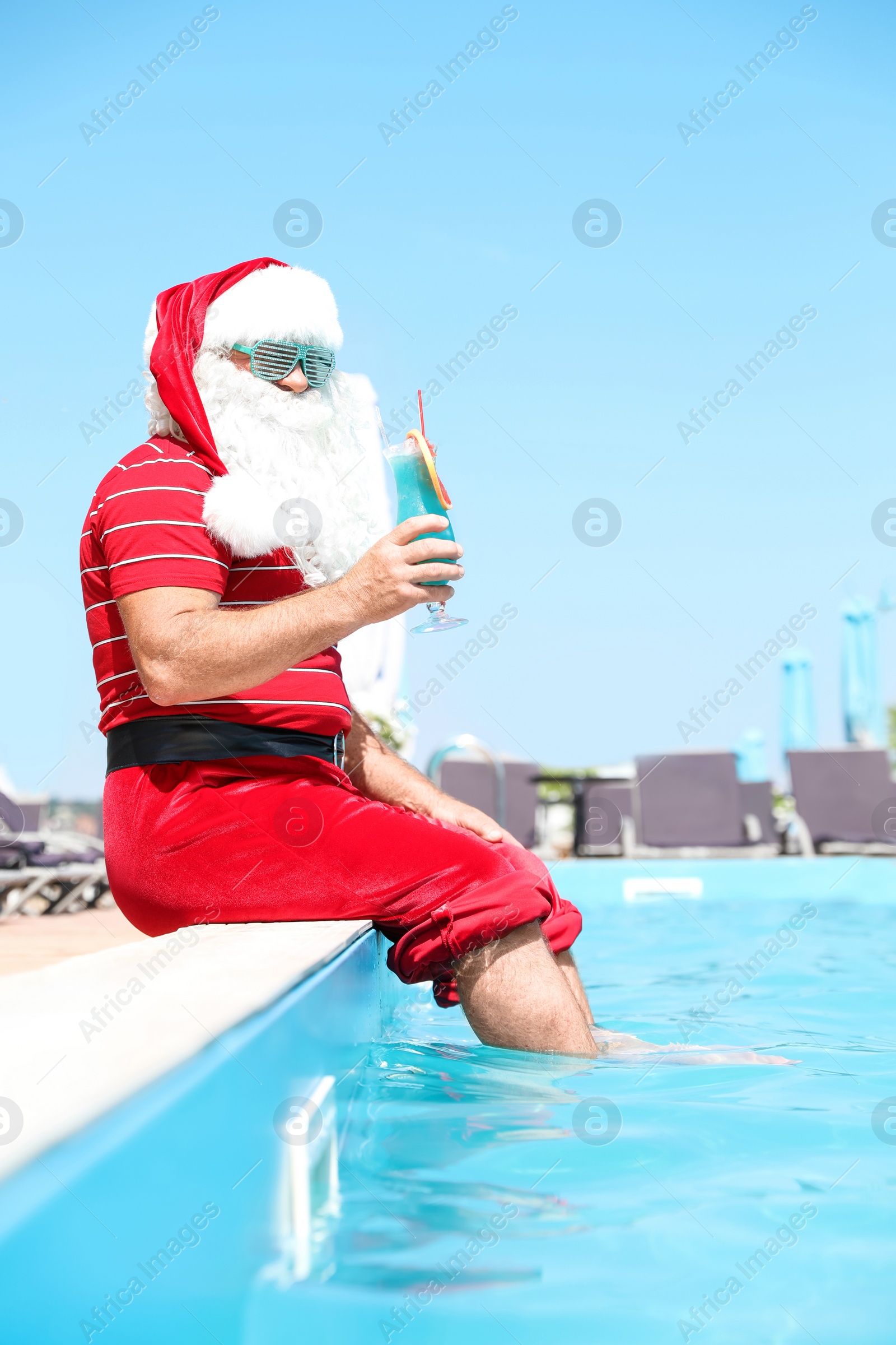 Photo of Authentic Santa Claus with cocktail near pool at resort