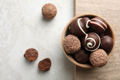 Many different delicious chocolate truffles on light table, flat lay