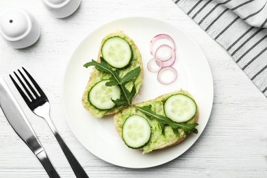 Photo of Flat lay composition with avocado sandwiches on white wooden table